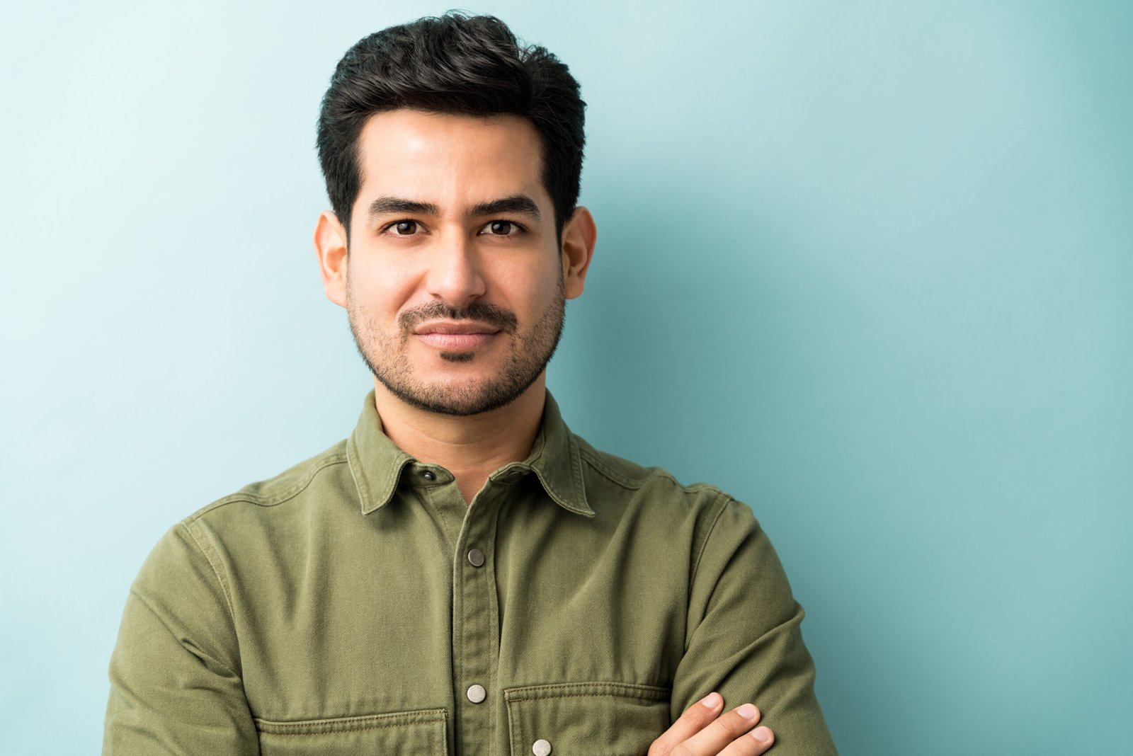Closeup of young Hispanic man in casuals at studio
